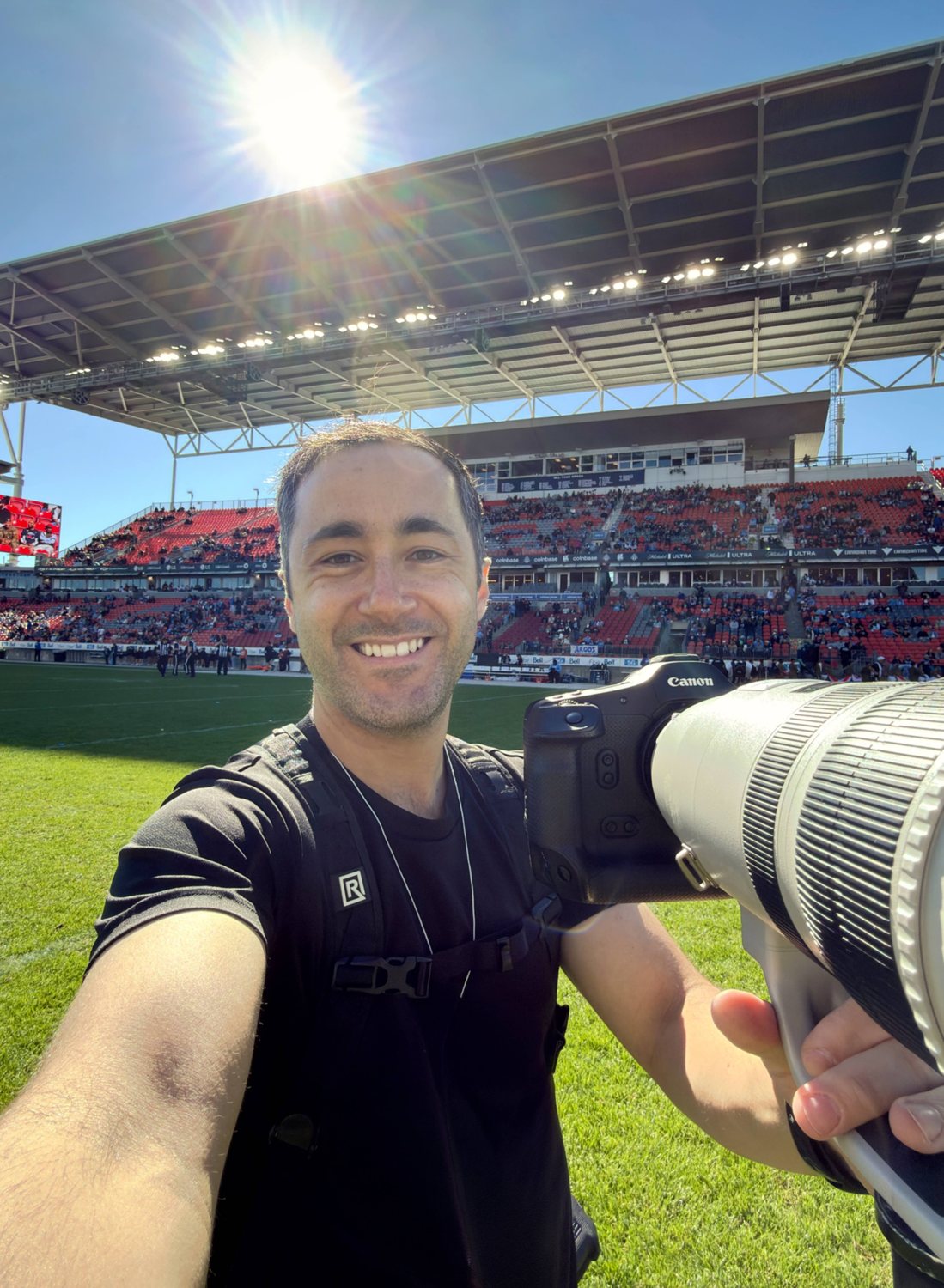 Kevin Raposo with his camera on the field at a Canadian Football League game