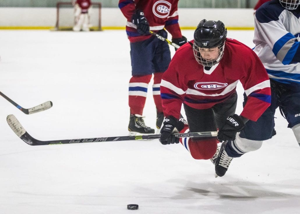 BURLINGTON, ON - Jan. 27, 2017: A player keeps his eyes on the puck while taking a tumble in Wave Hockey action.
