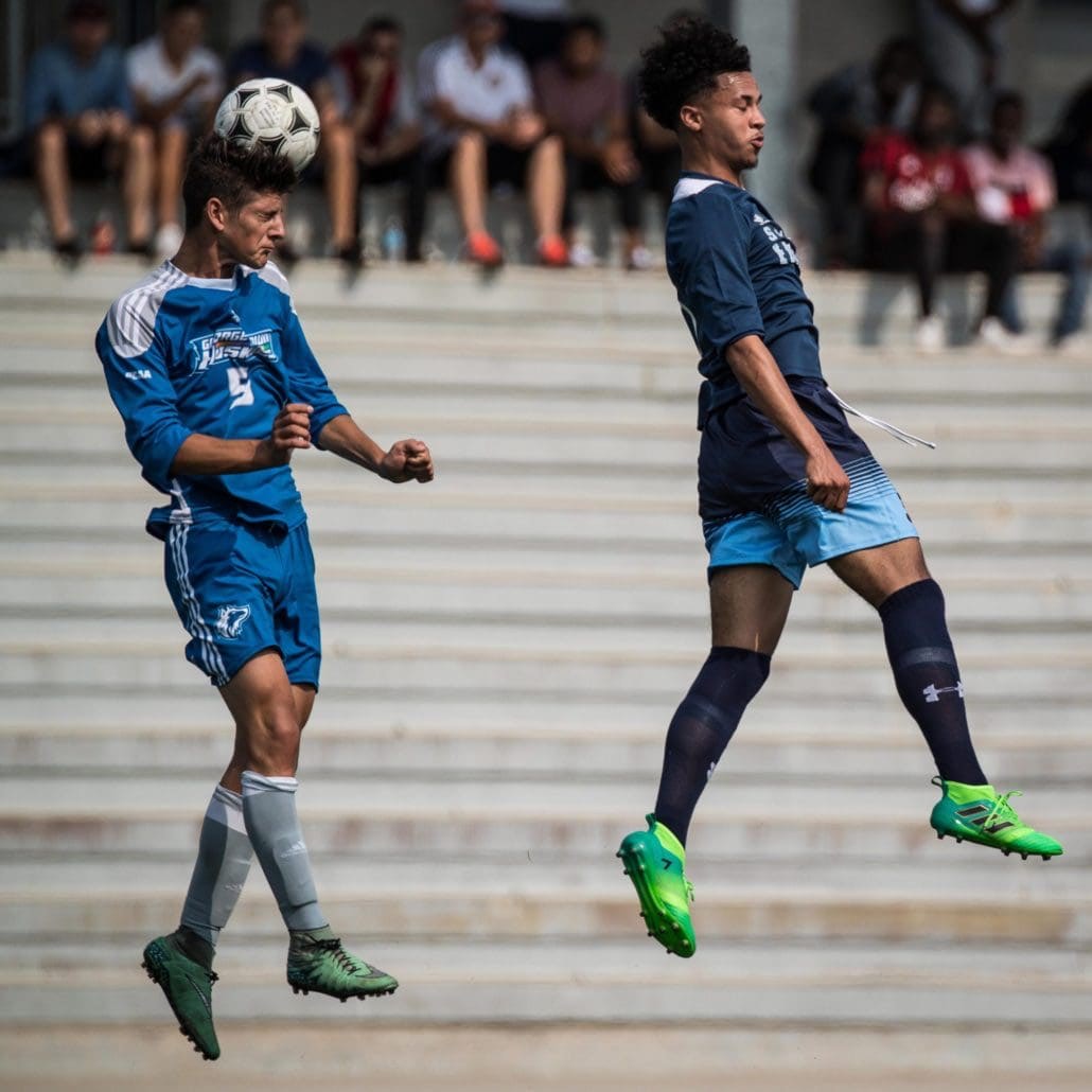 OAKVILLE, ON - SEP. 16, 2017: Players go airborne for the header in a game between the Sheridan Bruins and the George Brown Huskies.