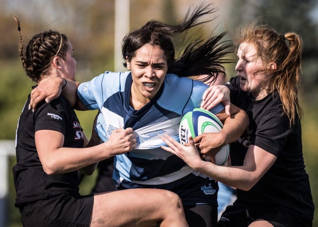 OAKVILLE, ON - NOV. 5, 2016: Sheridan player tries to get past two Seneca defenders at the inaugural OCAA Women's Rugby Sevens championship.